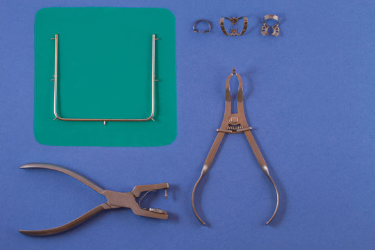 Tools for installing the cofferdam lying on a blue background.