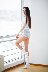 Fototapeta premium Beautiful woman standing near windows. Beautiful morning