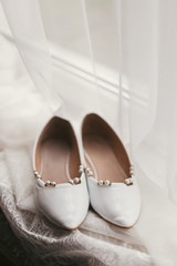 stylish white shoes on window in soft morning light. beautiful bridal getting ready for wedding day