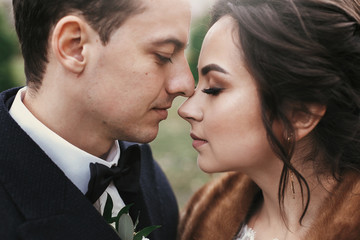 gorgeous bride with  and stylish groom gently hugging in european city street in autumn time. happy wedding couple embracing. romantic sensual moment of newlyweds. love and tender