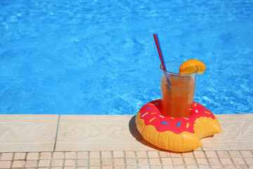 Tasty refreshing cocktail on edge of swimming pool