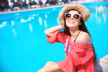 Beautiful young woman posing near swimming pool