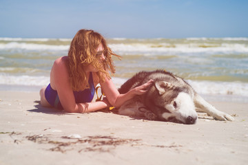 Young woman caress her dog at beach