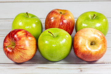 Green and red apples waiting to be eaten on the kitchen table