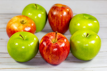Green and red apples waiting to be eaten on the kitchen table