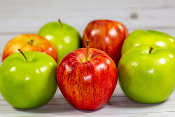 Green and red apples waiting to be eaten on the kitchen table