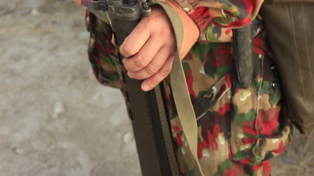Soldier in Camouflage Uniform with the Machine Gun