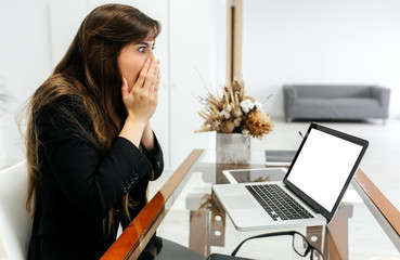 Business woman with surprised expression in her office