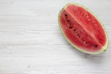 Fototapeta na wymiar Fresh cut watermelon on a white wooden surface. Copy space and text area.