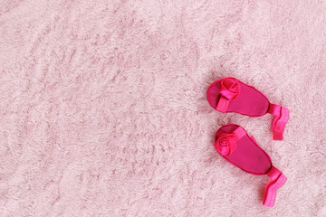 Obraz na płótnie Canvas Pair of dark pink baby girl sandals against light pink background.