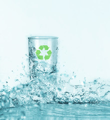 Pouring water into glass on light background