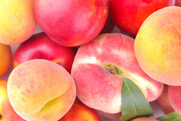 many different varieties of fresh peaches close-up. background