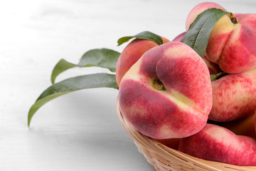 Ripe large figs peach in a basket on a white wooden background close-up