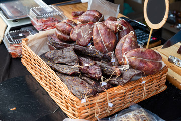 Smoked meat in a plastic bag in a basket on the counter of the store