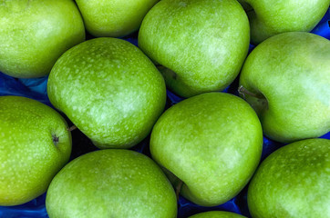 Pile of fresh ripe green apples at a local market