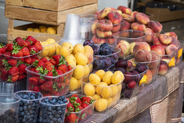Fototapeta na wymiar Fresh fruit in plastic trays for sale on the market counter