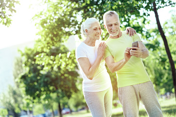 Convenient device. Progressive enthusiastic aged people learning how to use a smartphone