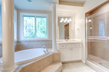 Luxury master bathroom with corner tub under stained-glass windows.