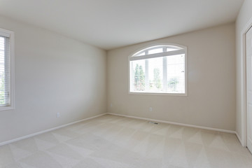 Glass double doors open to an empty room with carpet floor.