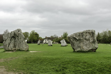 Part of the neolithic stone circle in Avebury, Wiltshire, United Kingdom. Part of the village in...
