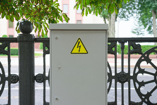 Switchboard high voltage on a street. Sign of lightning on the shield. 