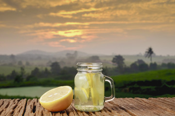 Lemon detox water  in the morning on green nature and sunrise background