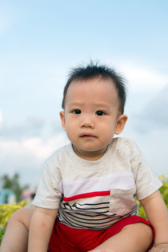 Portrait of Asian baby boy outdoor against blue sky