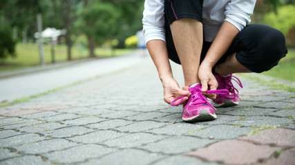 Woman jogger tighten her running shoe laces