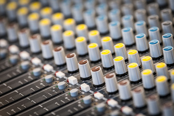 A sound mixing panel with various knobs