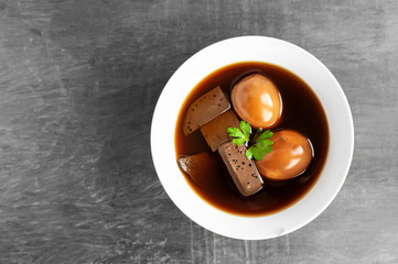 Eggs and pork boiled in the gravy on wooden table, Thai food.