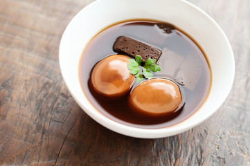 Eggs and pork boiled in the gravy on wooden table, Thai food.