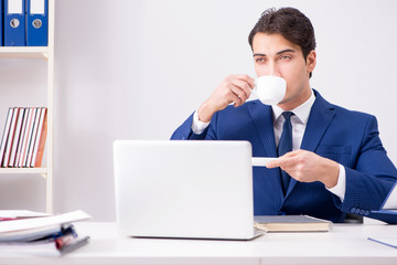 Young handsome businessman employee working in office at desk