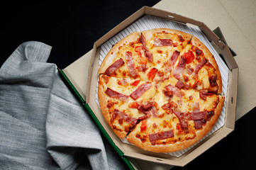 Delicious Italian pizza sliced ham, bacon and cheese with food ingredients on old kitchen table.