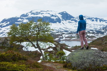 Naklejka premium Tourist woman enjoying mountains landscape in Norway