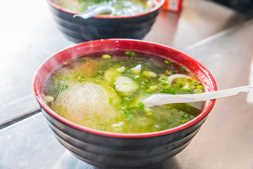 Squid noodles soup with green onion and fish balls