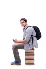 Young student sitting on top of book stack on white