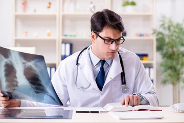 Young doctor looking at x-ray images in clinic