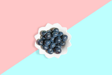 Large fresh garden berries blueberries, white plate with copy space for text on a colored background. The concept of vegetarian and healthy summer food. 
