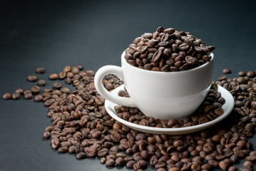 coffee in cup and coffee beans are the background.
