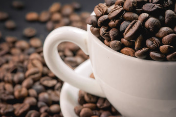 coffee in cup and coffee beans are the background.