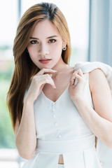 Naklejka premium beautiful asian woman portrait image in white elegance dress white room background