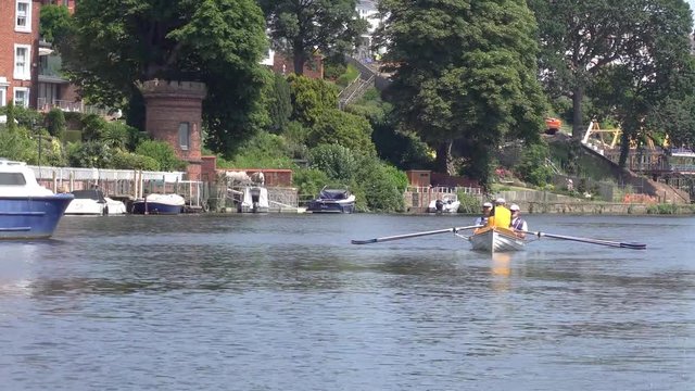 middle aged gentlemen enjoying a relaxing afternoon rowing a boat along the beautiful river Dee in Chester