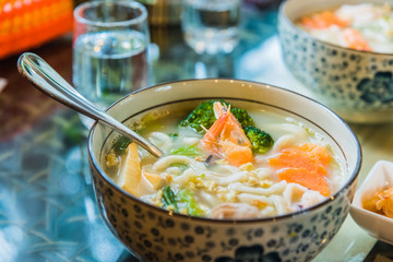 Chinese style noodles soup with broccoli, carrots, and shrimp - 214415974