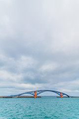 Blue and orange bridge on the ocean - 214416303