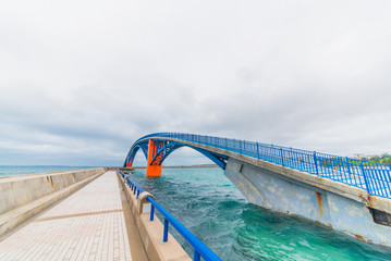 Blue and orange bridge on the ocean - 214416342