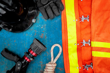 Outfit of Firefighter placed on old table background, Fire equipment concept.
