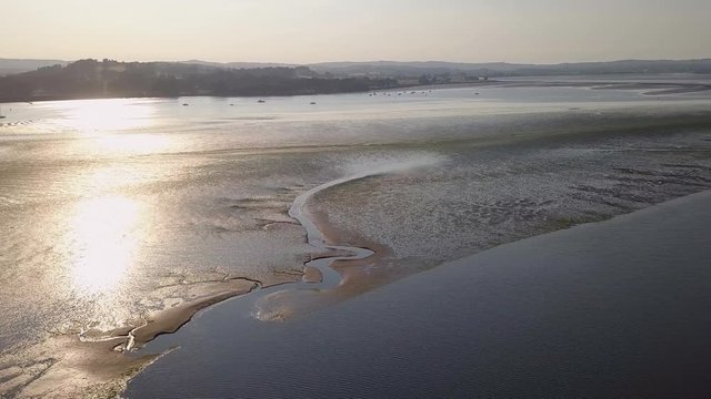Breathtaking view from the sky of coastal town in South England. Water and sand formations are visible in nature. Fishing is a past time, a harbour is near by. Water sports very popular.are