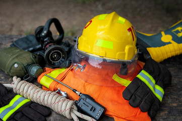 Fototapeta na wymiar Outfit of Firefighter placed on nature background, Fire equipment concept.