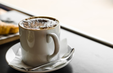 Cup of hot coffee in coffee shop.