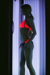The girl in a beautiful bathing suit. Sunbathing in the solarium